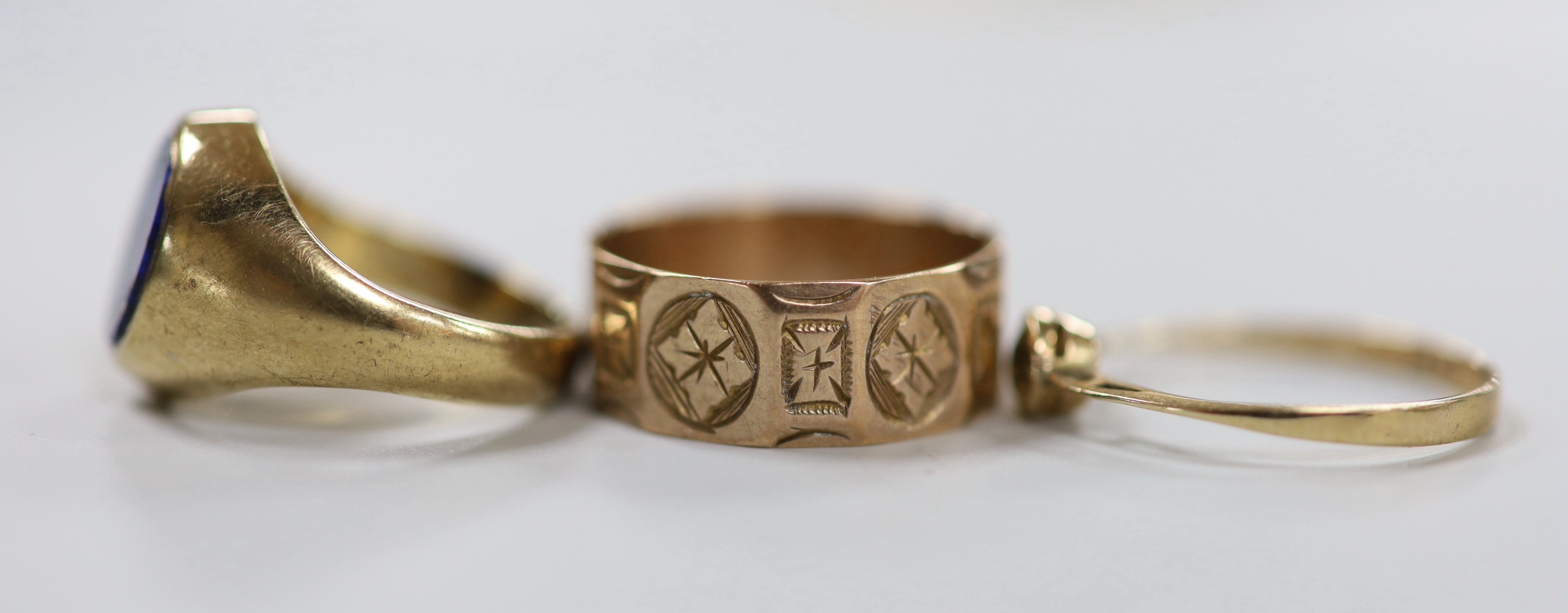 Three assorted 9ct rings including engraved band and lapis lazuli set, size I, gross weight 9.1 grams.